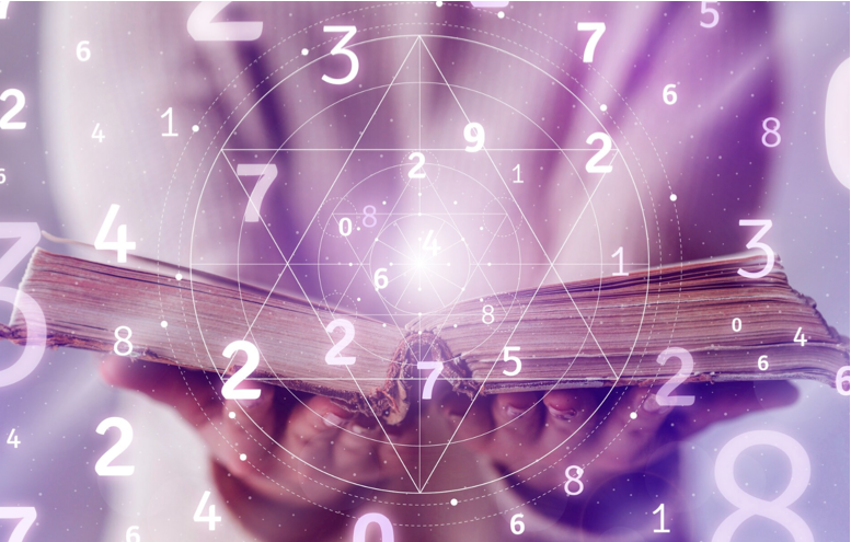 Wooden table with scattered numerology dice and candles in soft light